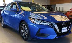 a blue car is parked in a showroom