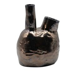 a small metal vase with two large pots in the shape of a heart on it's side