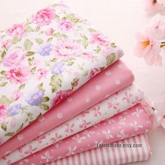 four pink and white floral fabrics stacked on top of each other