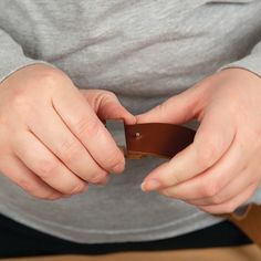 a person holding a piece of leather in their hands