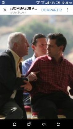 two men sitting next to each other on a bench with another man in the background