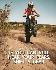 a man riding a dirt bike on top of a dirt covered field with a quote above it