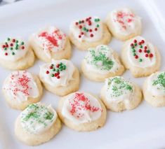 a white plate topped with cookies covered in frosting and sprinkles