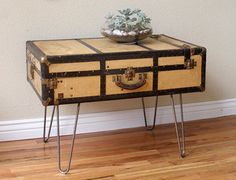 an old trunk table with hairpin legs and a potted plant on top