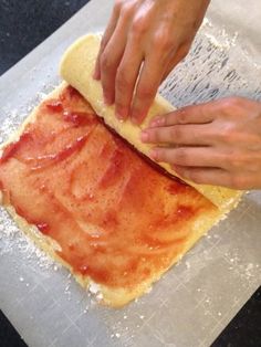 someone is making some kind of pizza on the counter top with their hands and fingers