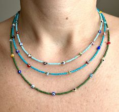 a woman wearing a multi - colored beaded necklace with two strands of beads on it