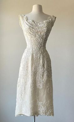 a white dress on a mannequin with an open back and lace overlay