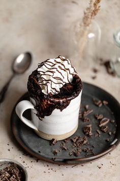 a chocolate dessert in a white cup on a black plate