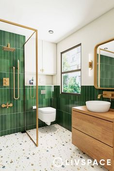 a bathroom with green tiles and gold fixtures on the shower, sink, toilet and mirror