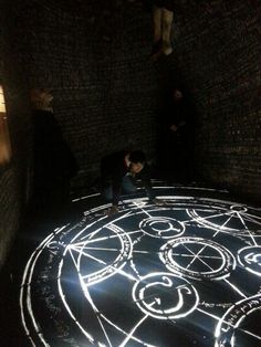 a man sitting on top of a floor covered in white lights