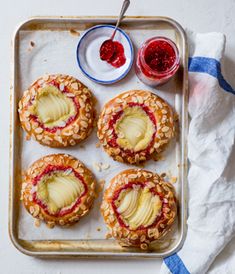 four pastries on a tray with jam and jelly