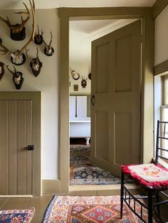 an entryway with antlers on the wall and rugs in front of it