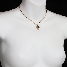 "Iridescent freshwater pearls glow alongside vibrant garnet stones in this delicate cross pendant necklace. This 24k gold plated necklace has been made with love in our NYC studio, and makes a wonderful Easter gift. Item Details -Materials: Garnet, freshwater pearls -Metal: 24K gold electroplated over brass -Size: Chain adjustable 14-17″ and pendant 1/2\" long -Lobster claw clasp -Handmade in our NYC studio -Complimentary gift wrapping -Item #: N4294 Repairs Policy: Repairs are free. Customers w Wire Wrapped Cross Pendant Necklace As Gift, Spiritual Cross Necklace With Pearl Charm, Wire Wrapped Cross Pendant Necklace For Gifts, Handmade Gold Crucifix Necklace, Wire Wrapped Crucifix Necklace For Gift, Spiritual Wire Wrapped Cross Pendant Necklace, Handmade Gold Crucifix Cross Necklace, Adjustable Red Cross Necklace, Elegant Gemstone Crucifix Necklace