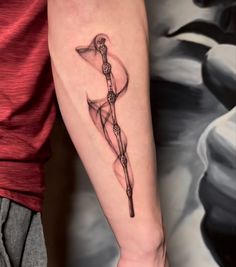 a person with a tattoo on their arm holding an object in one hand and a knife in the other