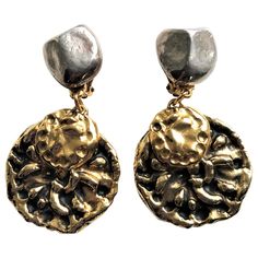 Very decorative clip-on earrings signed YSL. The upper part is made of pressed silver metal and looks like a Y. On the back you find the signature. The medallion attached is gold and black typical for YSL. Very distinctive color and material combination. Measurement: Length: 8 cm Width: 4,5 cm Upper part 2x2 cm Each earring weighs 26 grams. Excellent condition! Yves St Laurent, St Laurent, London Wedding, Locket, Clip On Earrings, Yves Saint Laurent, Metallica, Metallic Silver, Saint Laurent