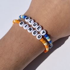 two bracelets with beads that say blue, white and orange on each one hand