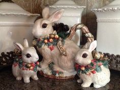 two white rabbits sitting next to each other on top of a counter with christmas decorations