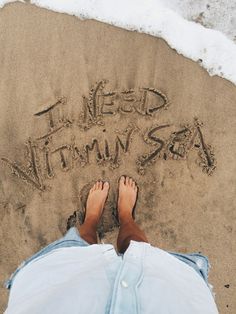 someone is writing in the sand with their feet