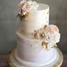 a three tiered white cake with flowers on top