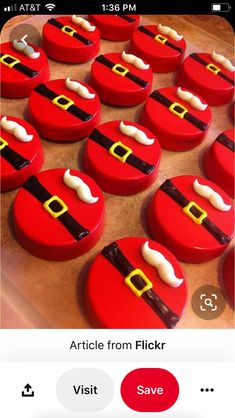 some red and black decorated cookies with santa clause on them, sitting next to each other