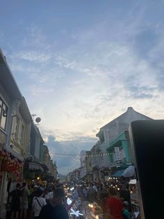 people are walking down the street at dusk