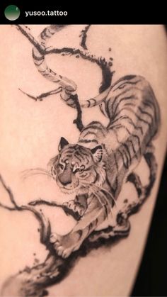 a tiger running across a tree branch tattoo