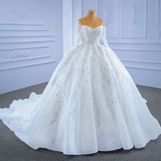 a white wedding dress on display in front of a mannequin's head