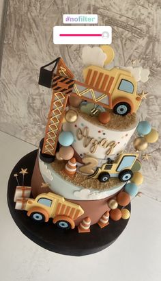 a three tiered cake decorated with trucks and balloons