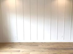 an empty room with wood floors and white walls