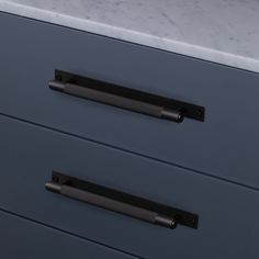 two drawers with handles on each drawer and marble counter top in the middle, one is dark blue