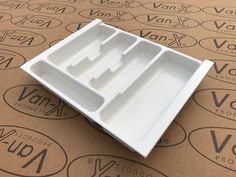 an empty white plastic container sitting on top of a cardboard box