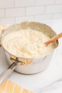 a pan filled with batter sitting on top of a counter next to a wooden spoon