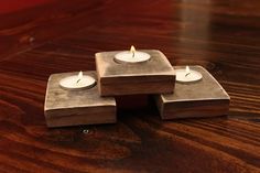 three small candles are placed on top of each other in the shape of cubes