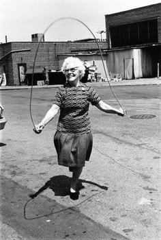 an old woman is playing with a hula hoop