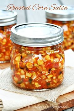 three jars filled with food sitting on top of a wooden table