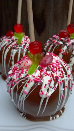 chocolate covered donuts with white icing and sprinkles on top are sitting on a table