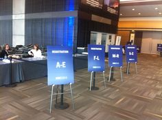 people sitting at tables with signs in front of them