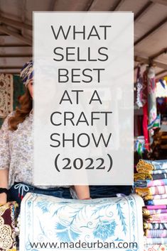 a woman standing in front of a pile of fabrics with the words what sells best at a craft show