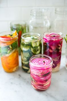 several jars filled with different types of vegetables