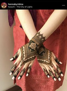 a woman with henna on her hands and arms is holding something in the other hand