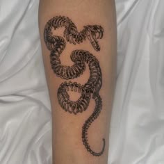 a tattoo on the leg of a person with a snake in it's claws