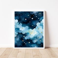 a painting with stars and clouds in the night sky on a wooden floor next to a white wall