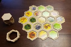 a board game with several pieces on the table next to it and an object that looks like hexagons