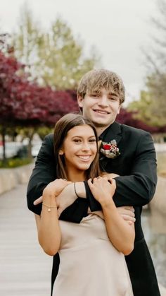 a young man and woman hugging each other