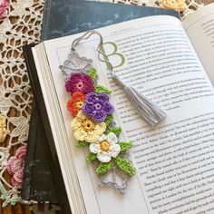 a bookmark made out of crochet flowers on top of an open book