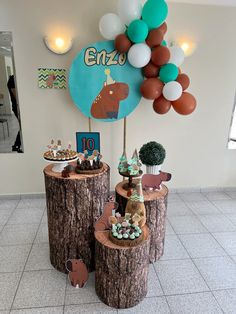 an animal themed birthday party with balloons and desserts on tree stumps in the lobby