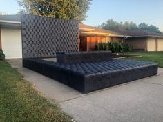 an inflatable couch sitting on top of a cement slab next to a house