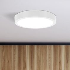 the ceiling light is on in front of wood paneled walls and wooden flooring