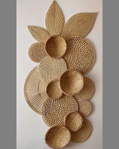 woven wall hangings with leaves and circles on the top of each one, made out of straw