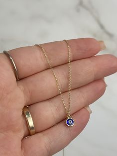 Protect and charm with our 14k Solid Gold Blue Evil Eye Necklace, a stylish accessory that blends elegance with a touch of mystique. This beautiful necklace features a striking blue evil eye pendant, known for its symbolic power to ward off negativity and bring good fortune. The pendant is gracefully set on an adjustable 15 to 16-inch cable chain, 1mm wide, allowing you to customize the fit for versatile styling options. Crafted from 14k solid gold, this necklace offers both durability and timel Everyday Blue Evil Eye Jewelry, Minimalist Blue Evil Eye Jewelry, Gold Evil Eye Symbolic Necklace, Blue Symbolic Evil Eye Jewelry, Elegant 14k Gold-filled Evil Eye Jewelry, Hand Painted Necklace, Simple Tattoo, 16 Inch Necklace, Cable Chain Necklace